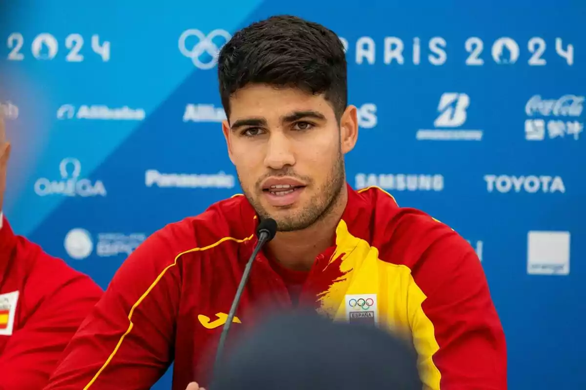 Carlos Alcaraz en una conferencia de prensa con el logo de los Juegos Olímpicos de París 2024 en el fondo. Carlos Alcaraz en una conferencia de prensa con el logo de los Juegos Olímpicos de París 2024 en el fondo.
