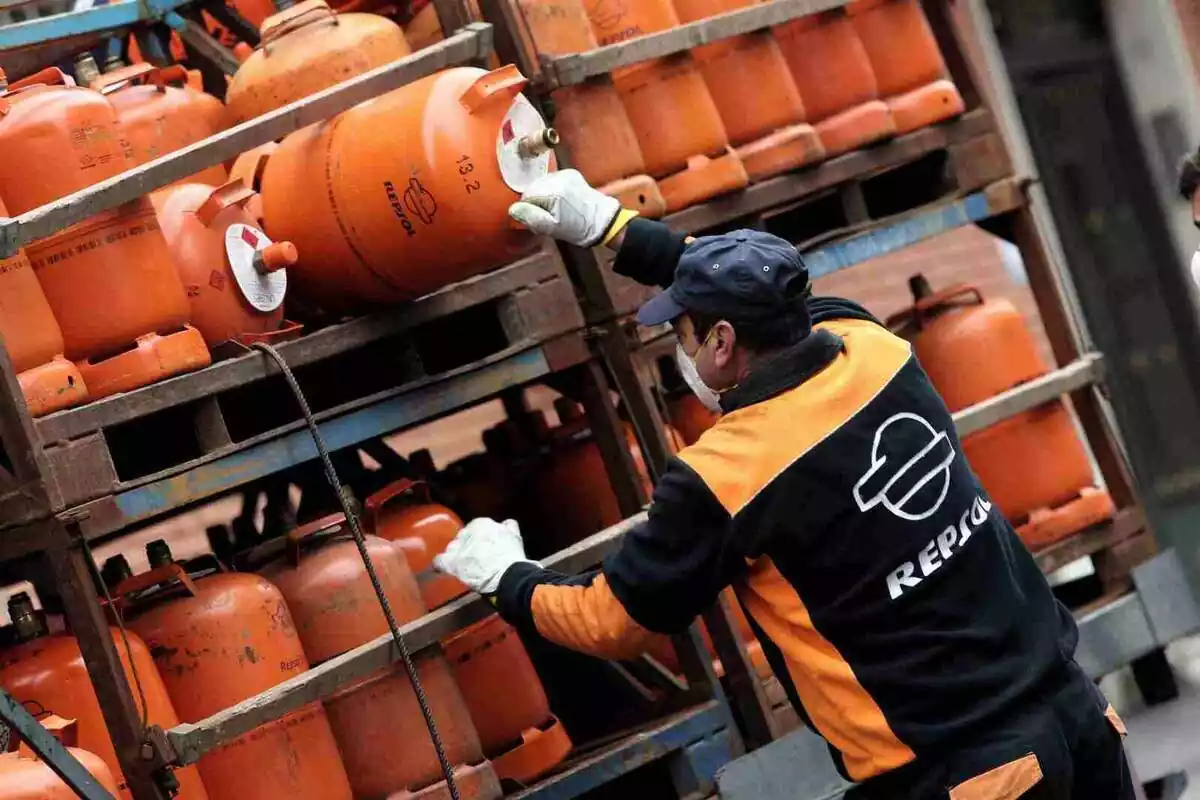 Un trabajador de Repsol cogiendo una bombona de butano de su camioneta