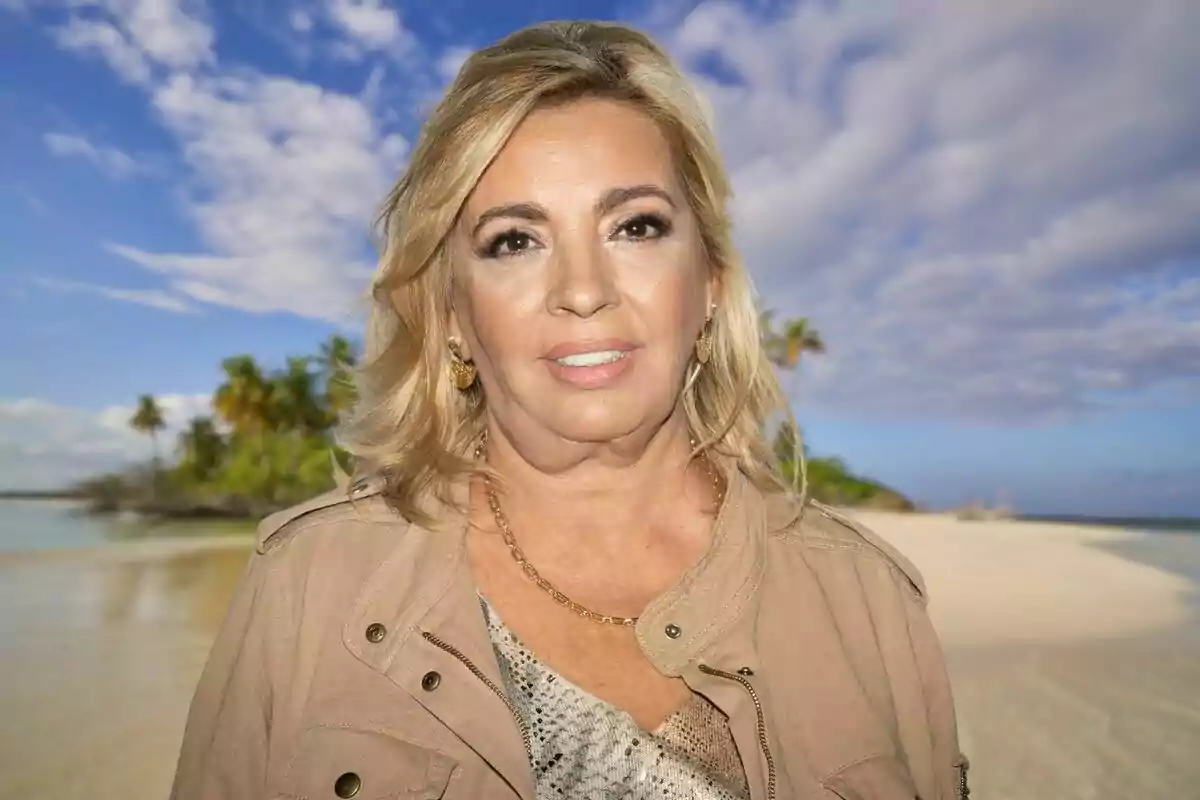 Una mujer rubia con chaqueta beige está de pie en una playa con palmeras y cielo azul al fondo.