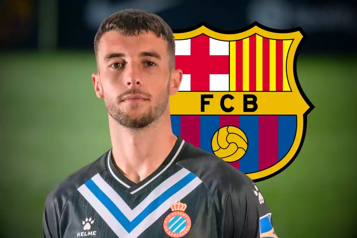 A player in RCD Espanyol uniform posing in front of the FC Barcelona crest.