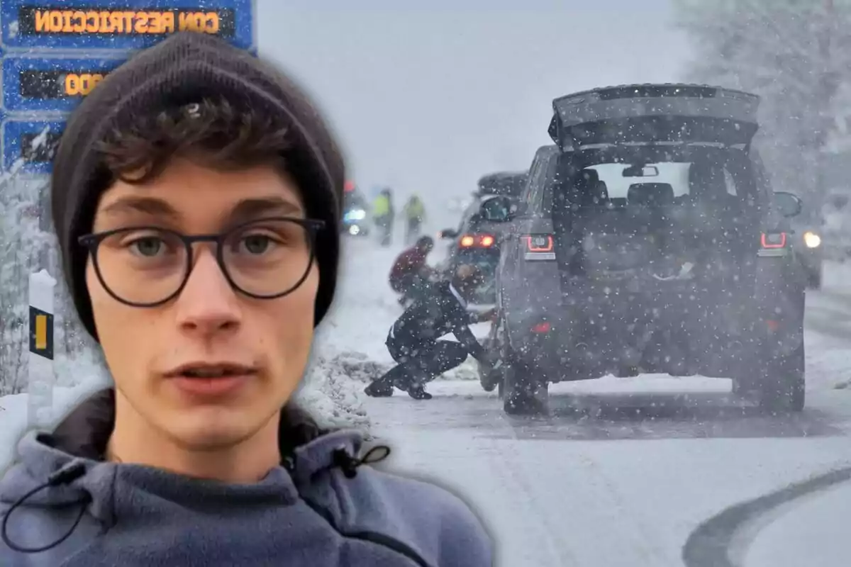 Un joven con gafas y gorro aparece en primer plano mientras al fondo se observa una carretera nevada con personas colocando cadenas en las llantas de un vehículo.