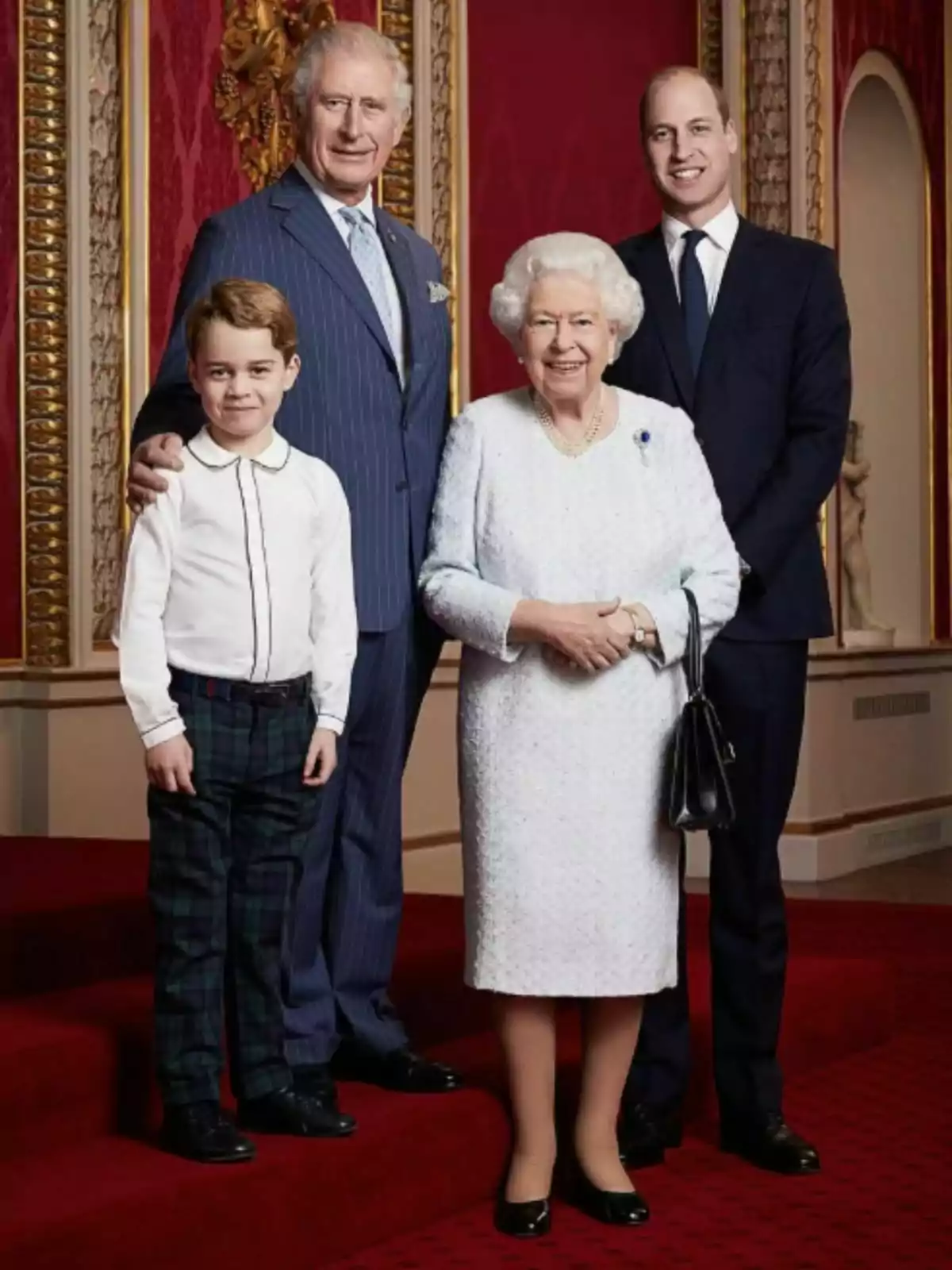 Un grup de persones posant en un entorn elegant amb catifa vermella i parets decorades.