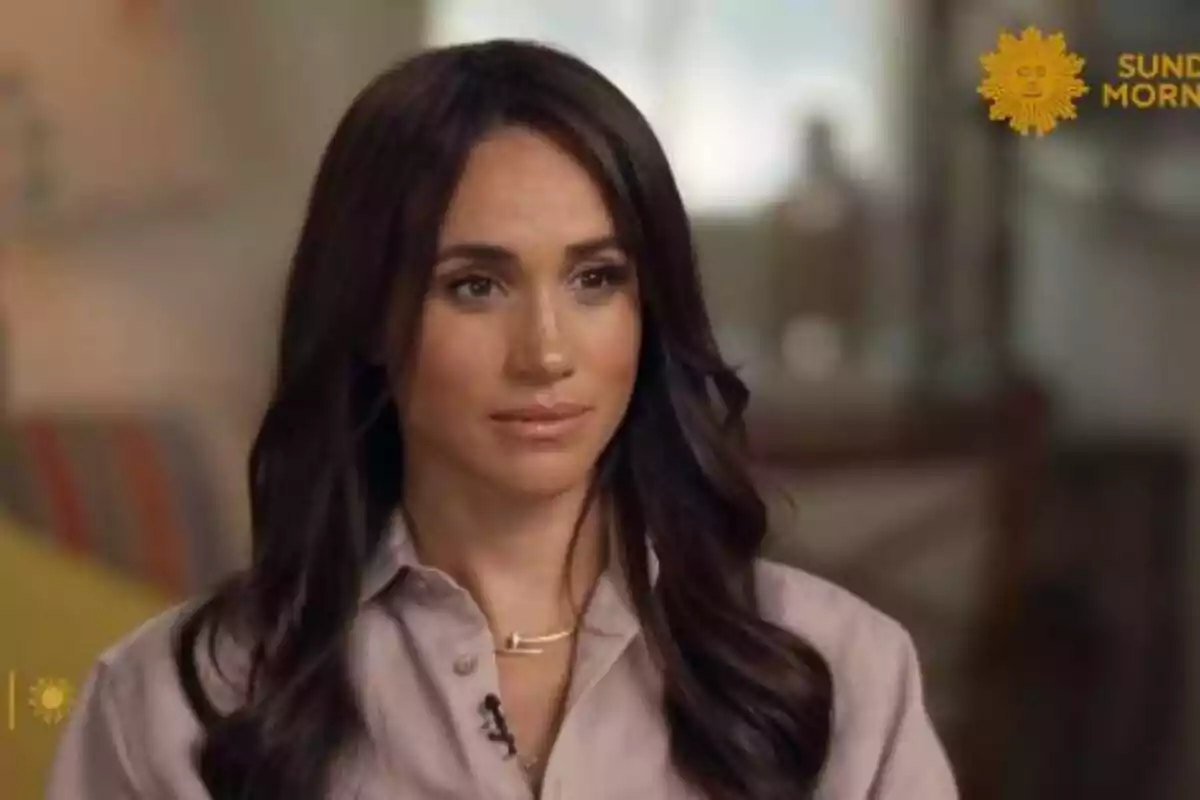 Meghan Markle vestida con una camisa clara, aparece en una entrevista en un programa de televisión matutino.