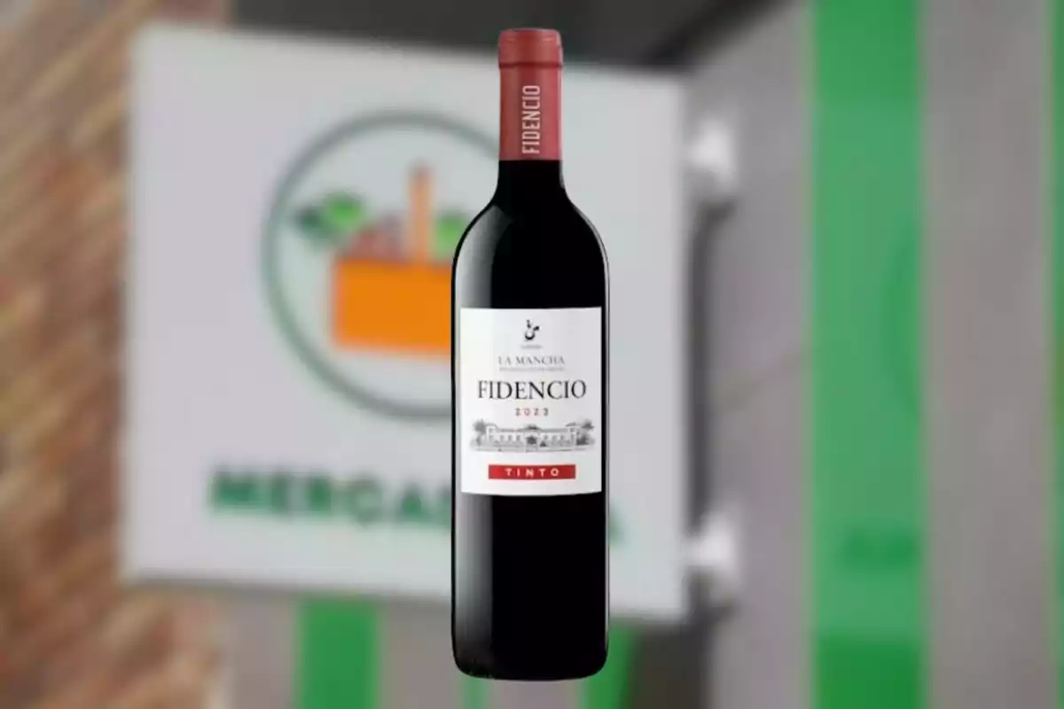 Botella de vino tinto Fidencio 2023 frente a un cartel borroso de supermercado. Botella de vino tinto Fidencio 2023 frente a un cartel borroso de supermercado.